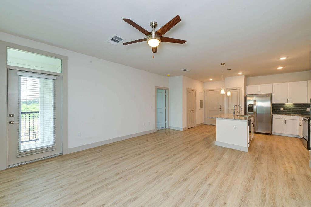 an empty living room with a ceiling fan and a kitchen at Legacy at Cibolo, Texas