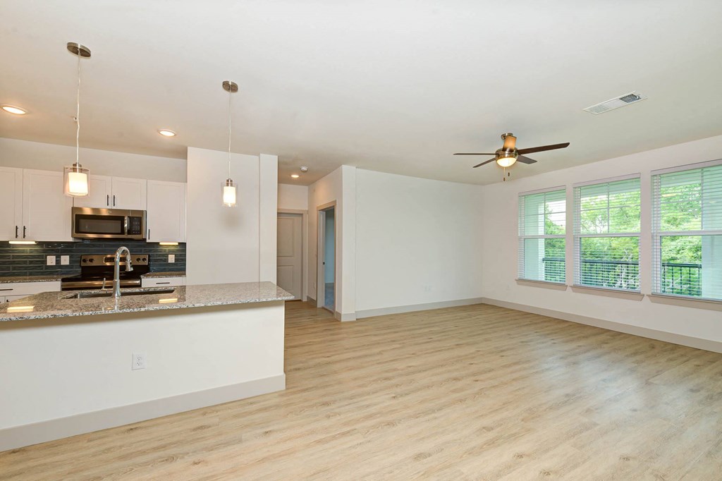 an empty living room with a kitchen and a ceiling fan at Legacy at Cibolo, Boerne