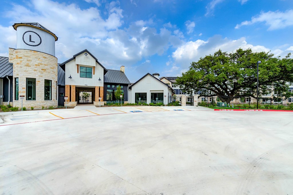 an empty parking lot in front of a building with trees at Legacy at Cibolo, Boerne, TX