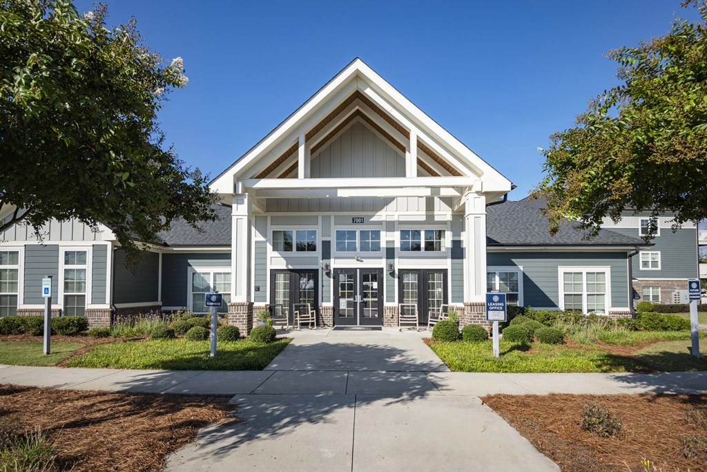 A large building with a triangular roof and a covered entrance at Waterleaf at Neely Ferry Apartments, Simpsonville, 29680