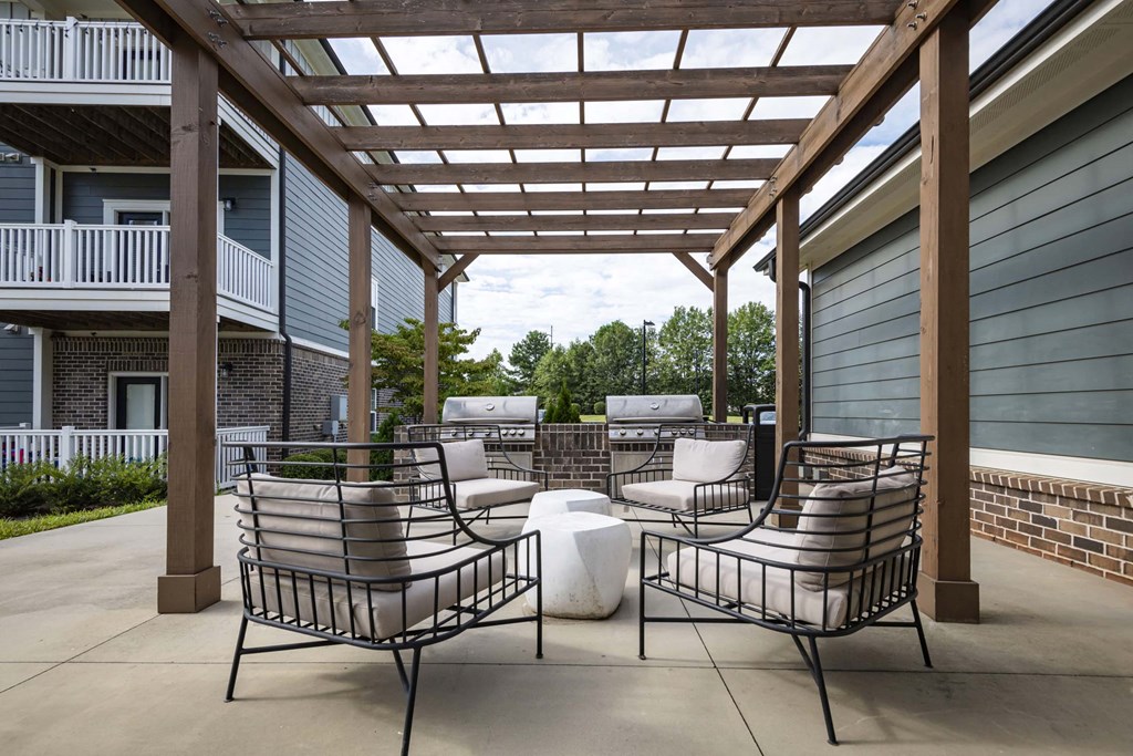 Two chairs and a table are on a patio at Waterleaf at Neely Ferry Apartments, South Carolina