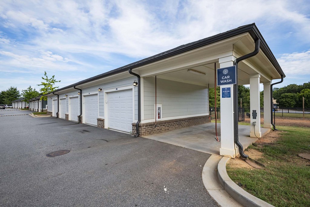 A car wash station is located under a covered area with a sign above it at Waterleaf at Neely Ferry Apartments, South Carolina