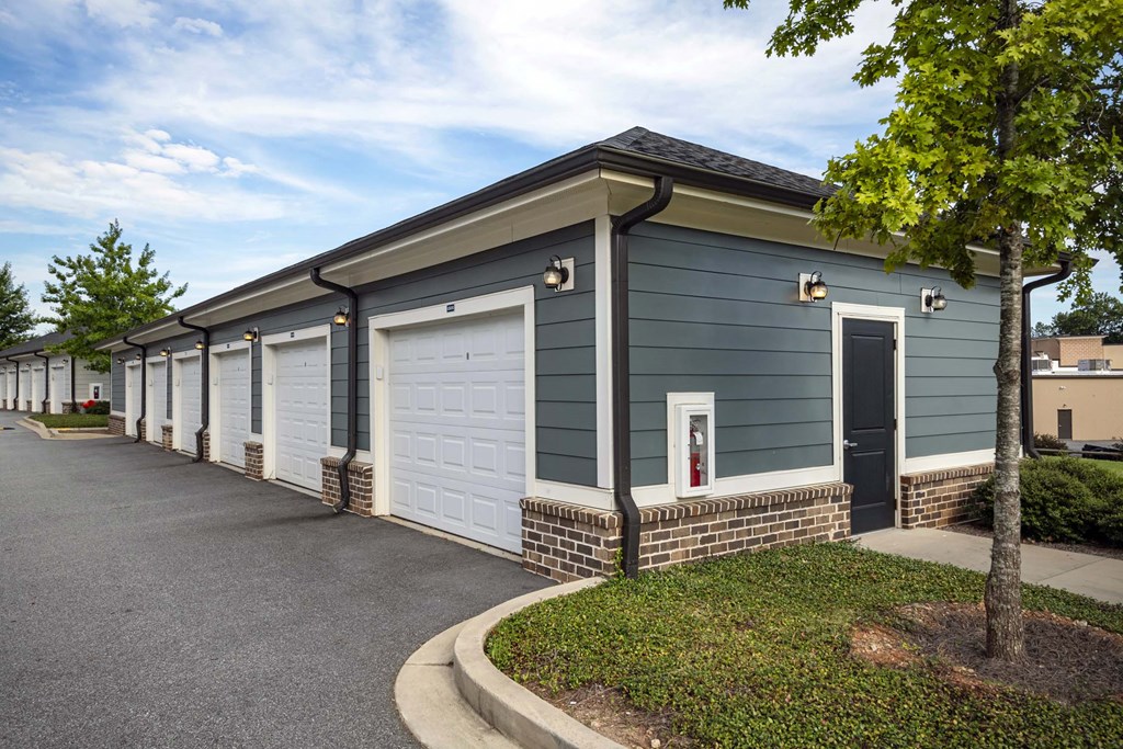 A row of garages with a tree in front of the first one at Waterleaf at Neely Ferry Apartments, South Carolina 29680