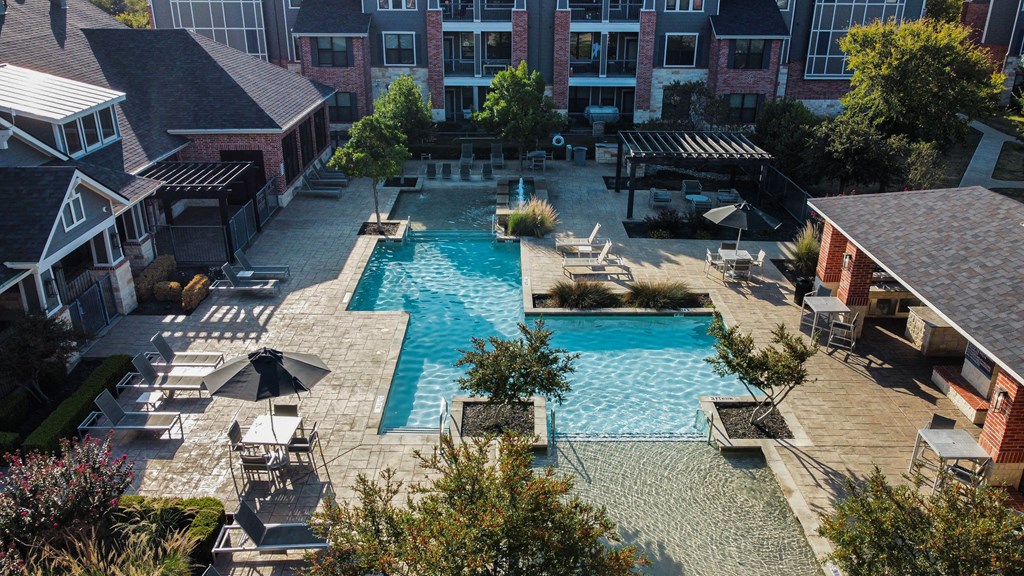 an aerial view of a swimming pool with lounge chairs and umbrellas at Platinum Castle Hills, Lewisville, 75056