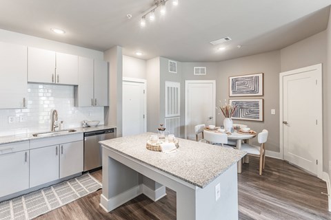 A kitchen with a table and chairs in the middle of the room.