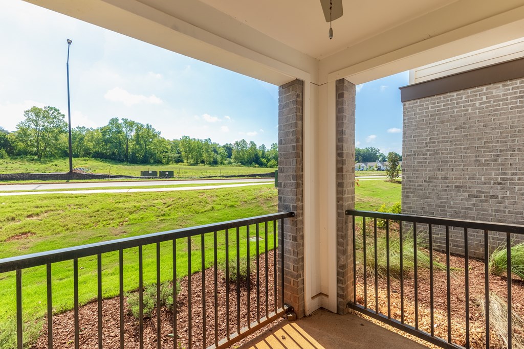 Balcony with a black railing and a view of a grassy field at Prosper Madison Oaks, Madison Alabama
