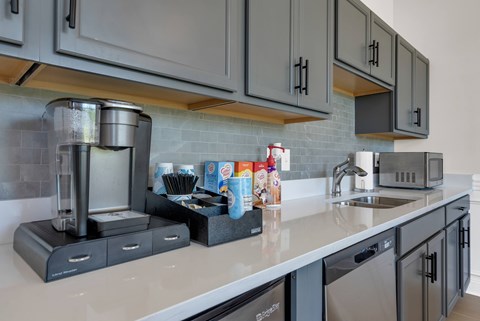 A kitchen with a coffee maker and a microwave on the counter.