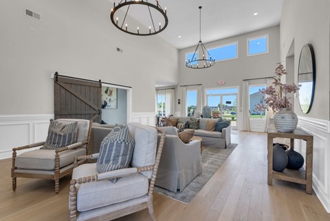 A living room with a grey sofa and a wooden floor.