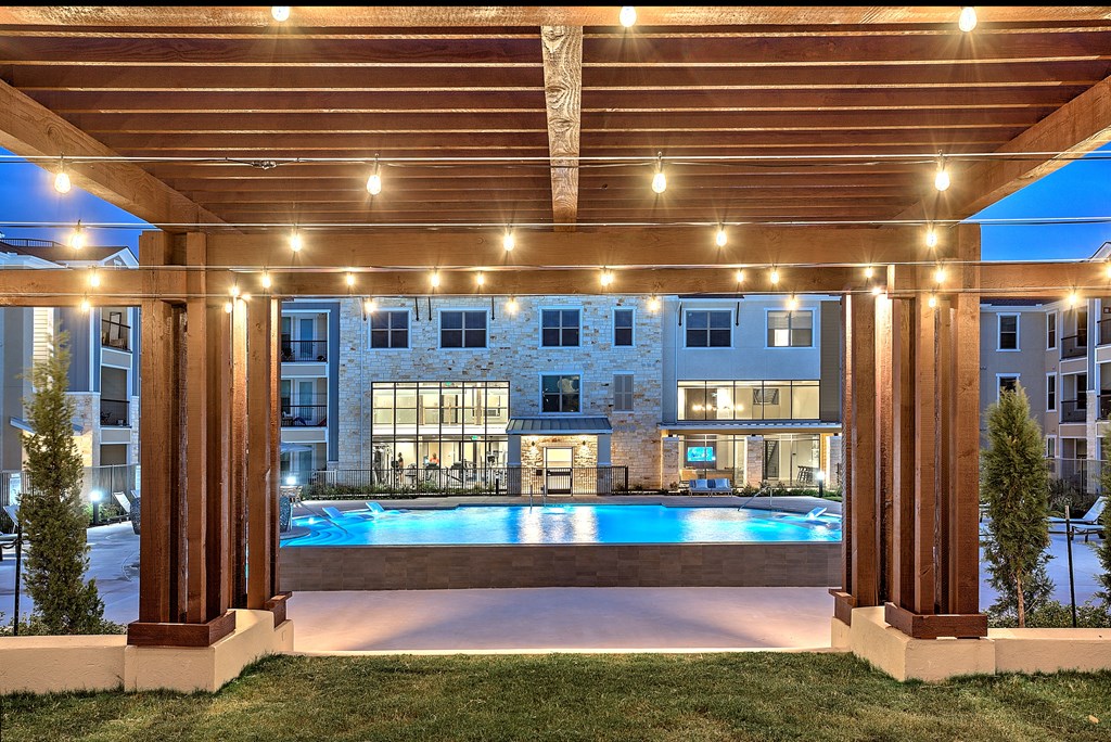 Pool by a wooden pergola with lights at Edge and Stone, San Antonio, 78260