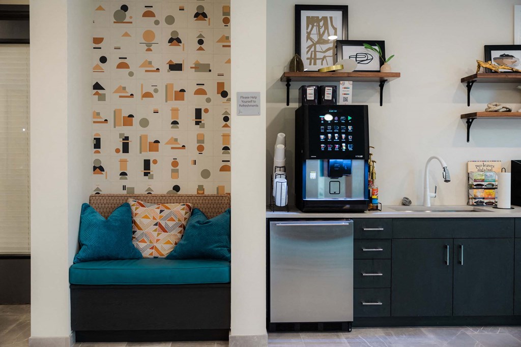 A kitchen with a blue couch and a wall with a pattern of shapes at Hudson at Renaissance Apartments, Wilmington, North Carolina
