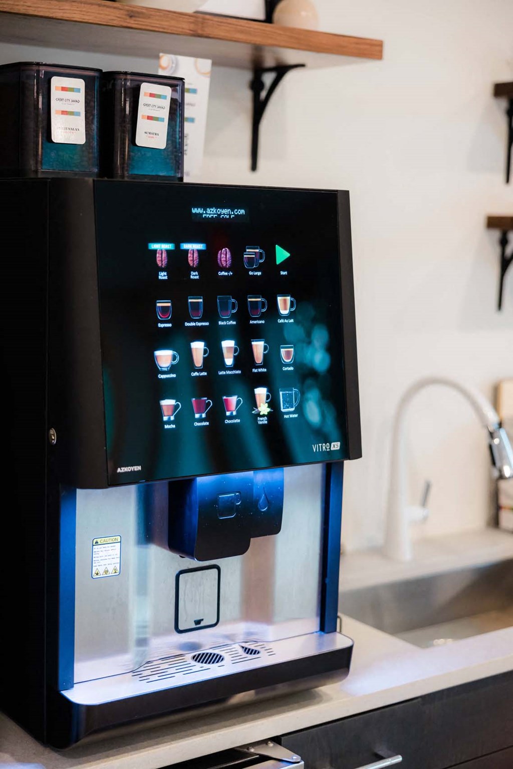A black vending machine with a digital display and a variety of drink options at Hudson at Renaissance Apartments, Wilmington, NC 28405