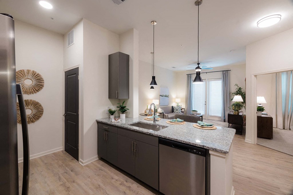 A modern kitchen with dark wood cabinets and a large island at Hudson at Renaissance Apartments, North Carolina