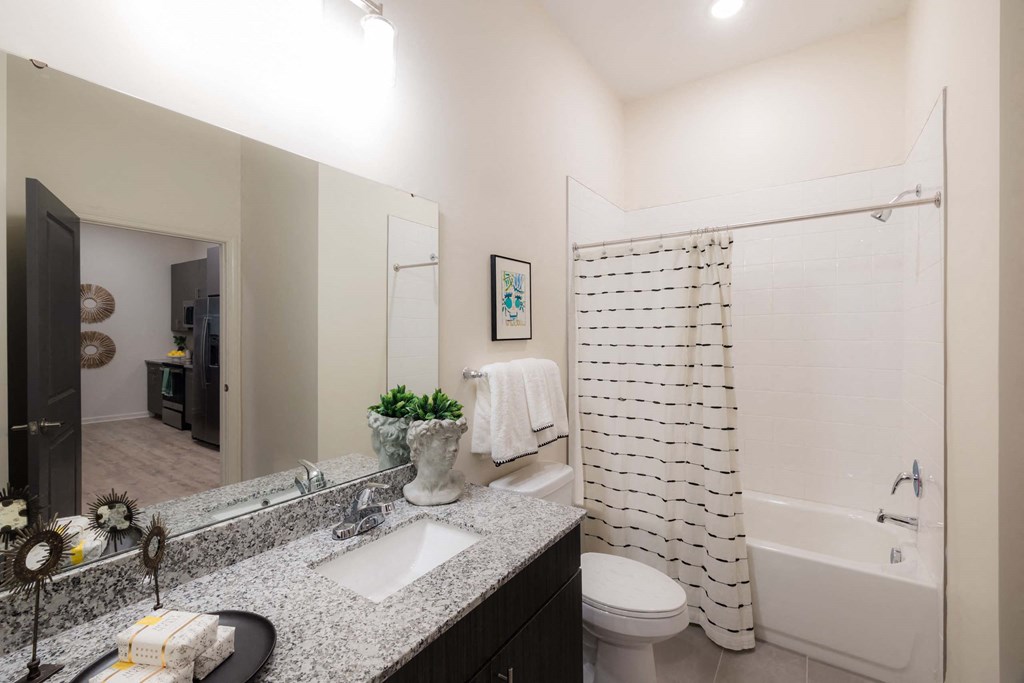 A bathroom with a white shower curtain at Hudson at Renaissance Apartments, Wilmington, NC 28405