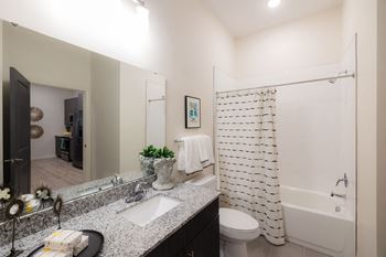 A bathroom with a white shower curtain and a white toilet at Hudson at Renaissance Apartments, Wilmington 28405