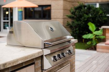 A stainless steel grill is on a patio at Hudson at Renaissance Apartments, Wilmington 28405