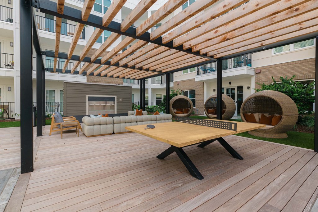 A wooden table is in the middle of a wooden deck at Hudson at Renaissance Apartments, Wilmington 28405