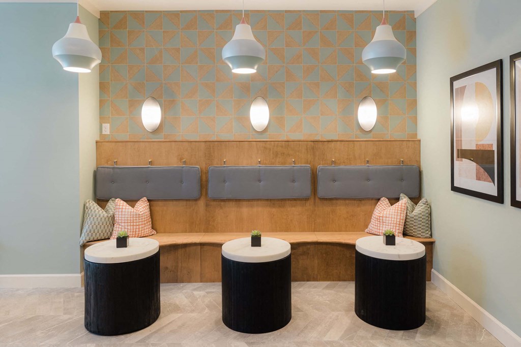 A room with a bench and three tables at Hudson at Renaissance Apartments, North Carolina