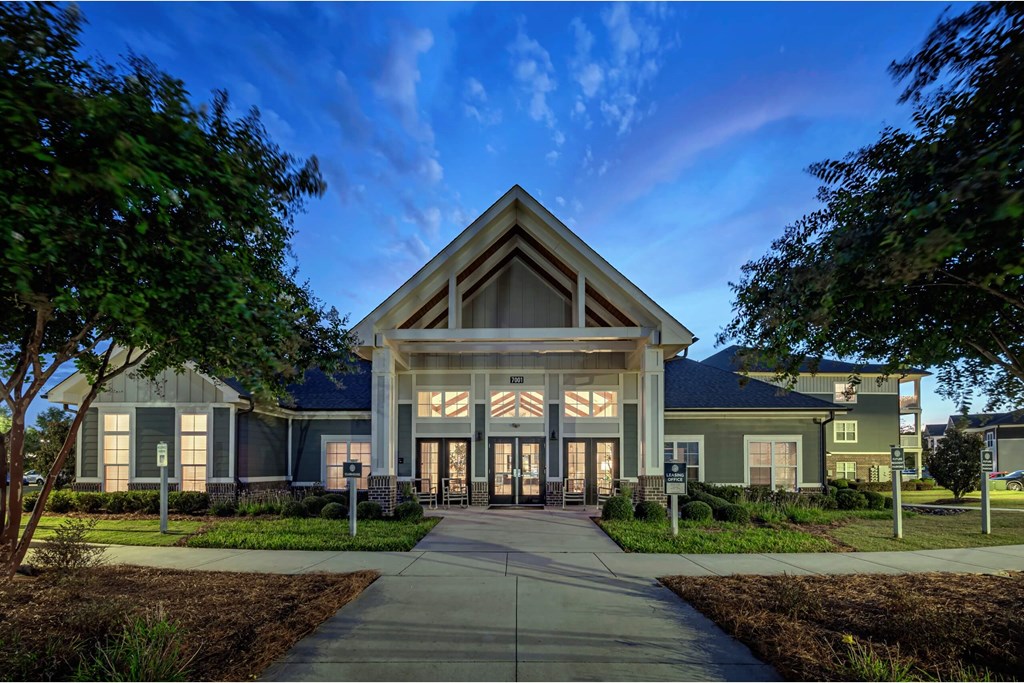 A modern building with a large front entrance and a pathway leading to it at Waterleaf at Neely Ferry Apartments, Simpsonville, SC