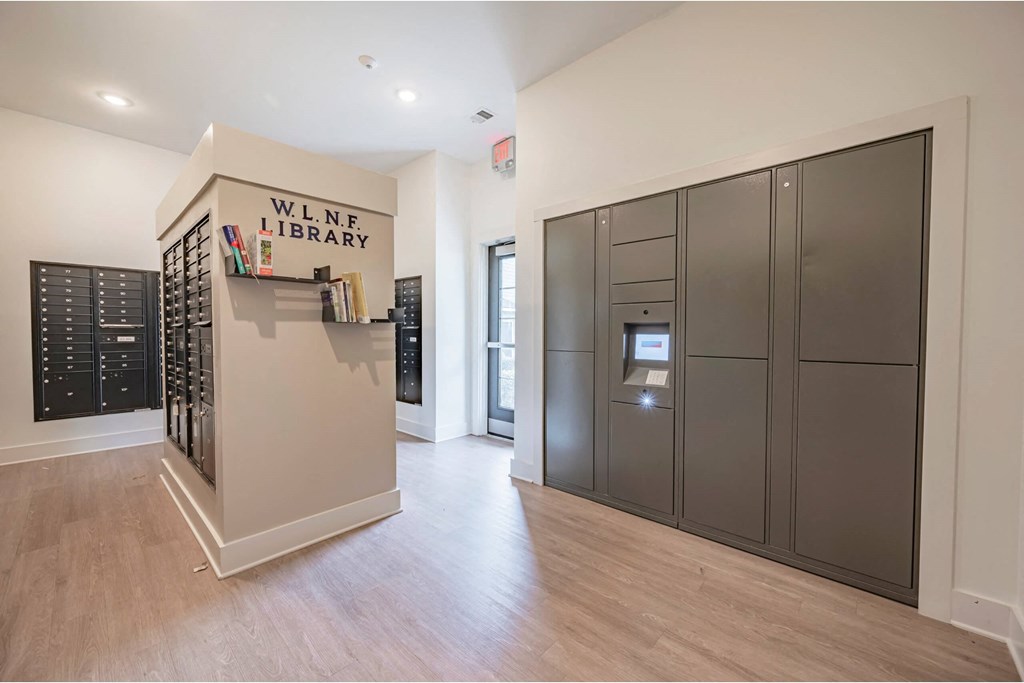 A library with a wooden floor and a wall of books at Waterleaf at Neely Ferry Apartments, Simpsonville, 29680