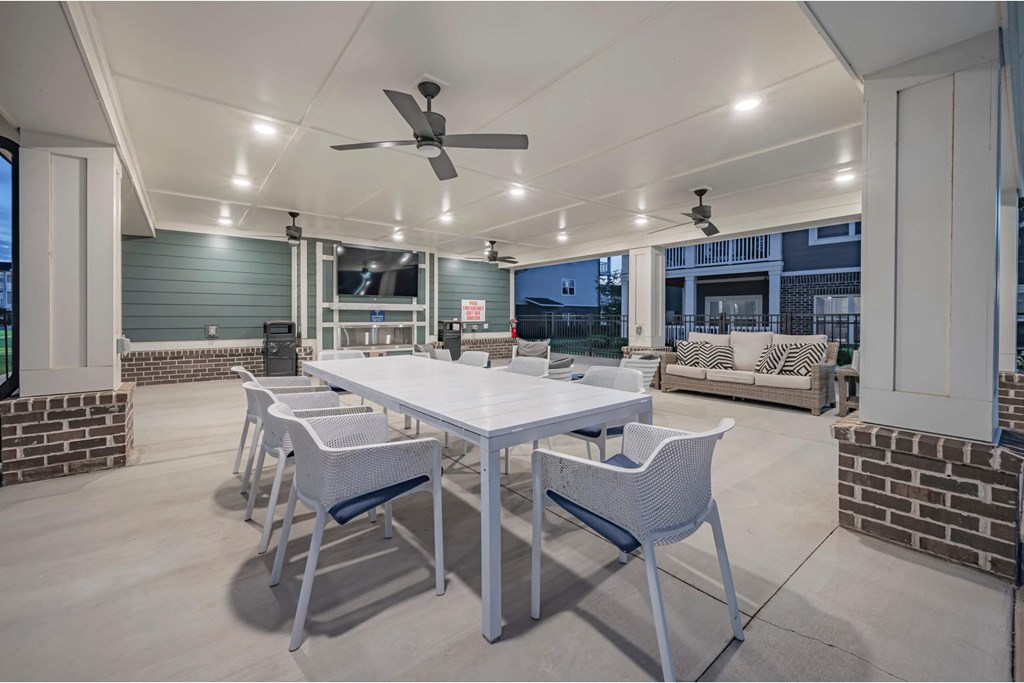 A patio with a table and chairs is shown at Waterleaf at Neely Ferry Apartments, Simpsonville, 29680