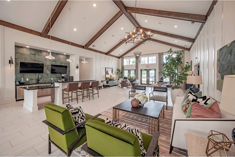 A modern living room with a stone fireplace and a large green sofa.