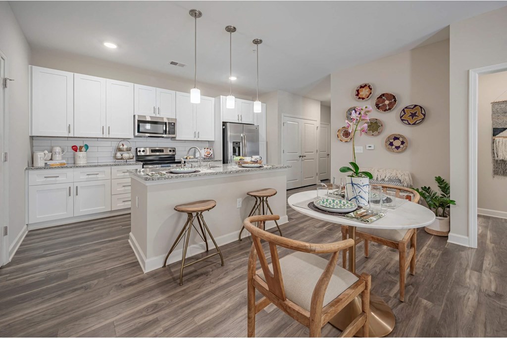 A kitchen with a table and chairs in the middle at Waterleaf at Neely Ferry Apartments, Simpsonville, South Carolina