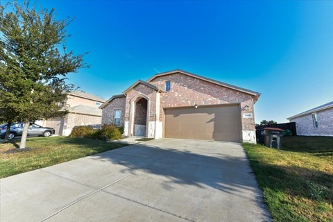 A house with a garage door and a driveway.