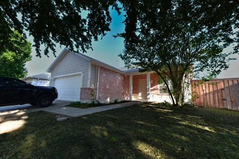 A house with a black car parked in front.