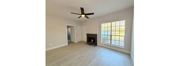 A room with a fireplace and a ceiling fan.