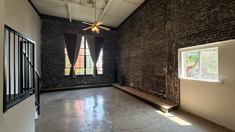 A room with a brick wall and a ceiling fan.