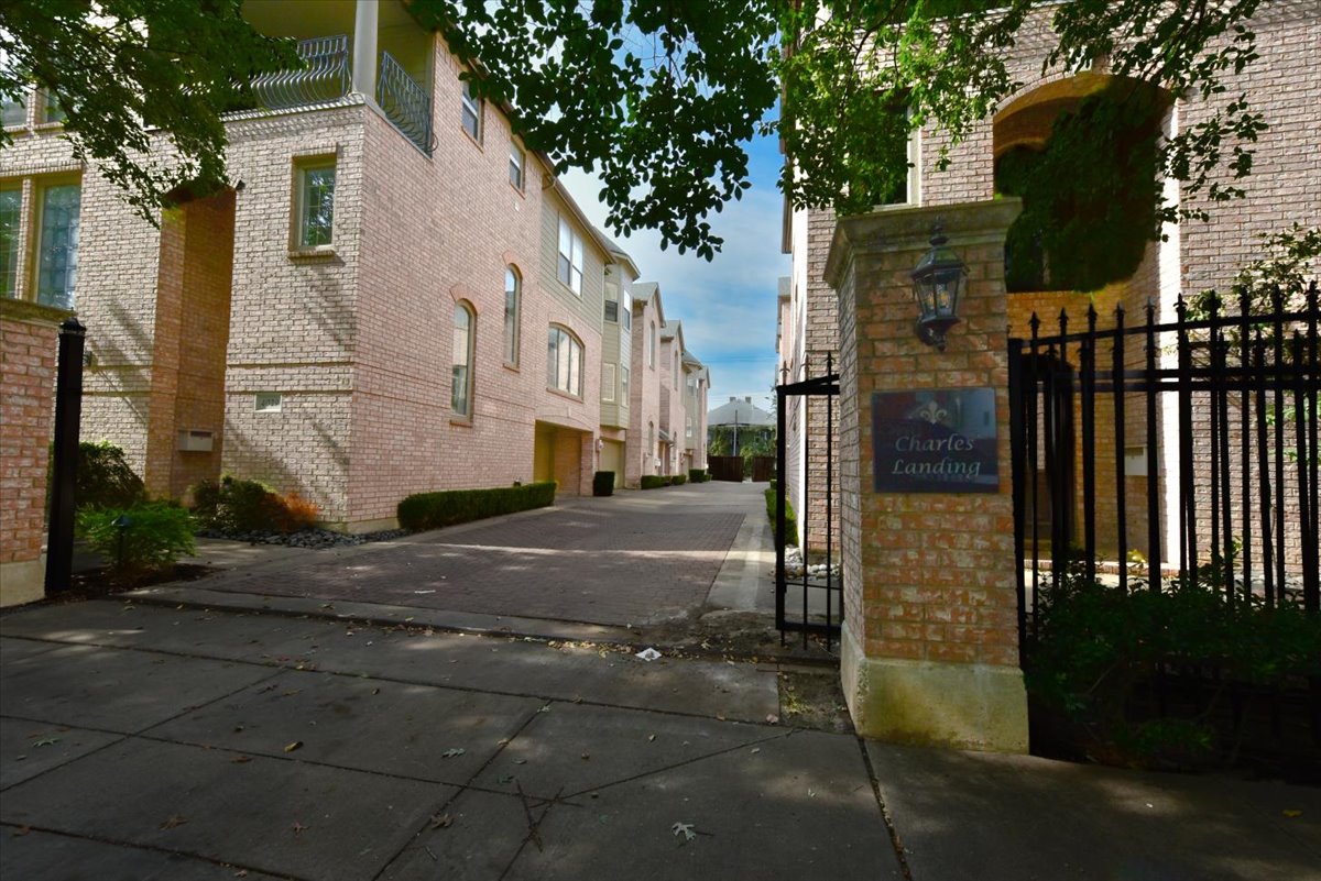 A gated entrance to a brick building with a sign that says Charles Landford.