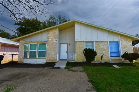 A house with a white door and a small front yard.