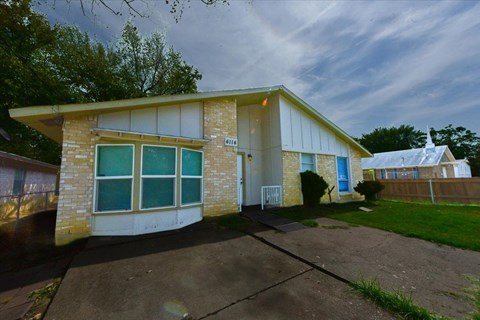 A house with a blue door and a white garage door.