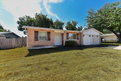 A house with a brown brick exterior and a white garage door.