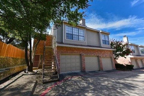 A house with a garage and a tree in front.