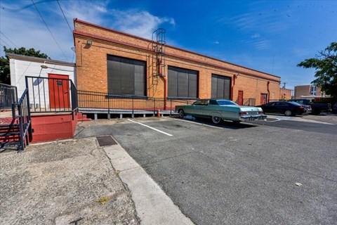A red and white building with a green car parked in front.