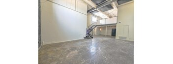 A room with a concrete floor and a metal staircase.