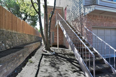 A tree growing out of a concrete planter in front of a brick building.