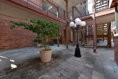 A courtyard with a tree, a lamp post and a potted plant.