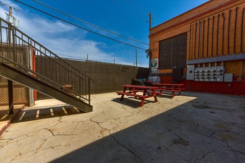 A red picnic table is in front of a red building.