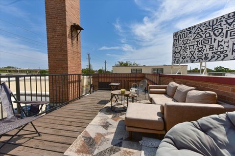 A patio with a table and chairs and a large mural on the wall.