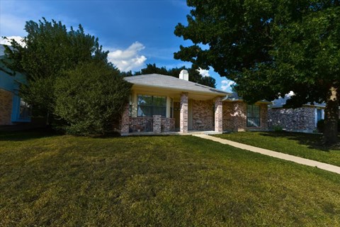 A house with a well-manicured lawn in front.