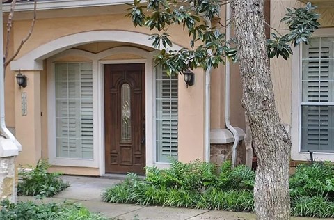 A house with a brown door and white shutters.
