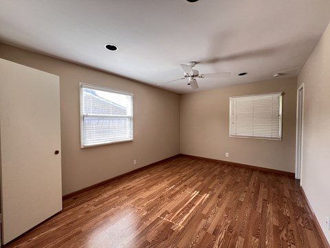 A room with wooden flooring and a ceiling fan.