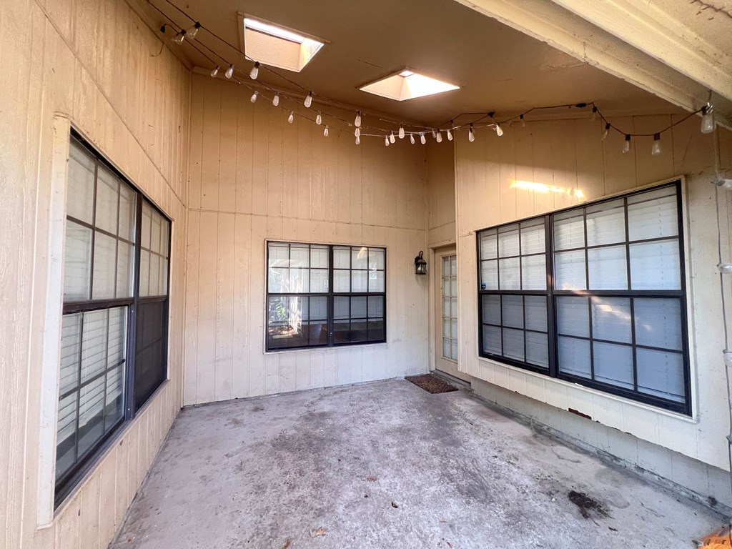 A room with a concrete floor and windows on the right side.
