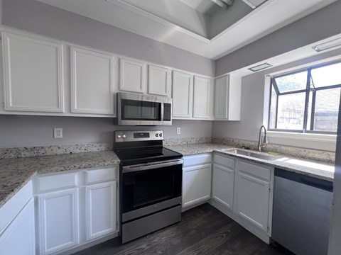 A kitchen with white cabinets and a black oven.