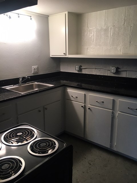 A kitchen with a stove and sink.