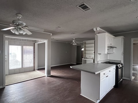 A kitchen with white cabinets and a ceiling fan.