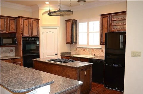 A kitchen with granite countertops and wooden cabinets.