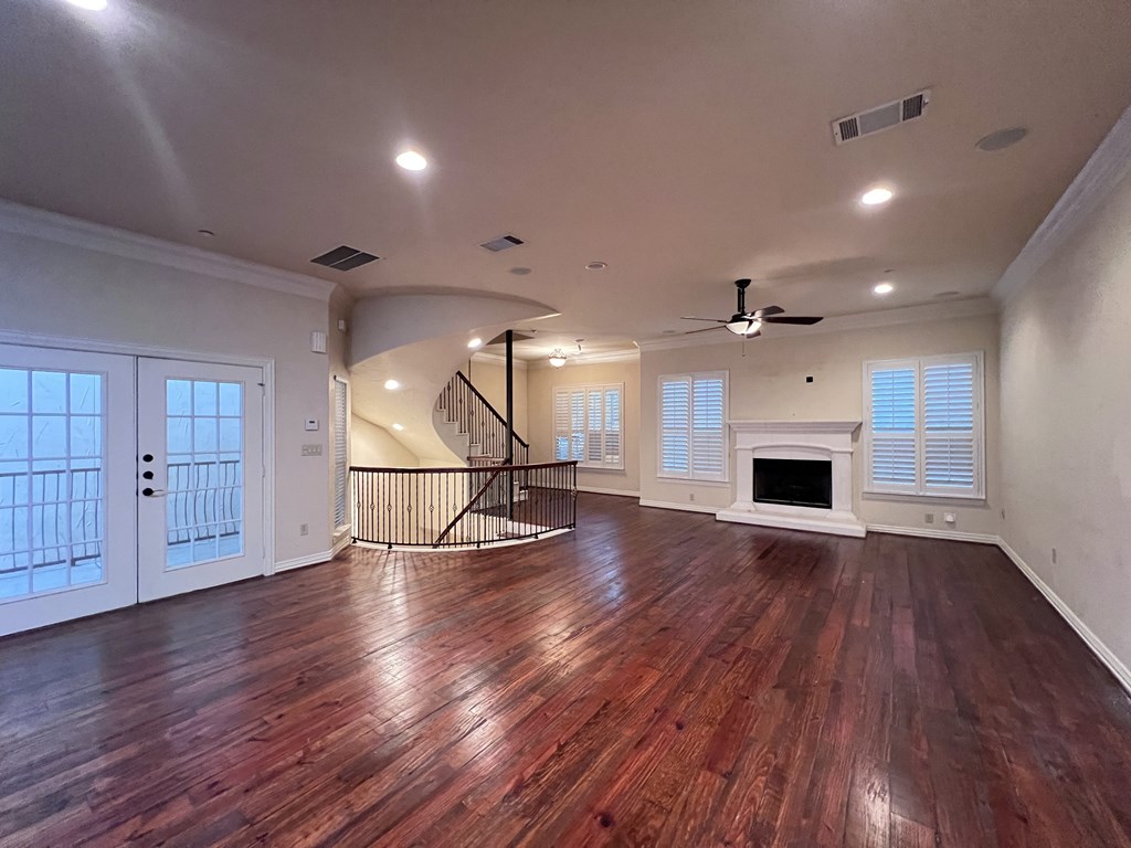 A room with wooden floors and a spiral staircase.